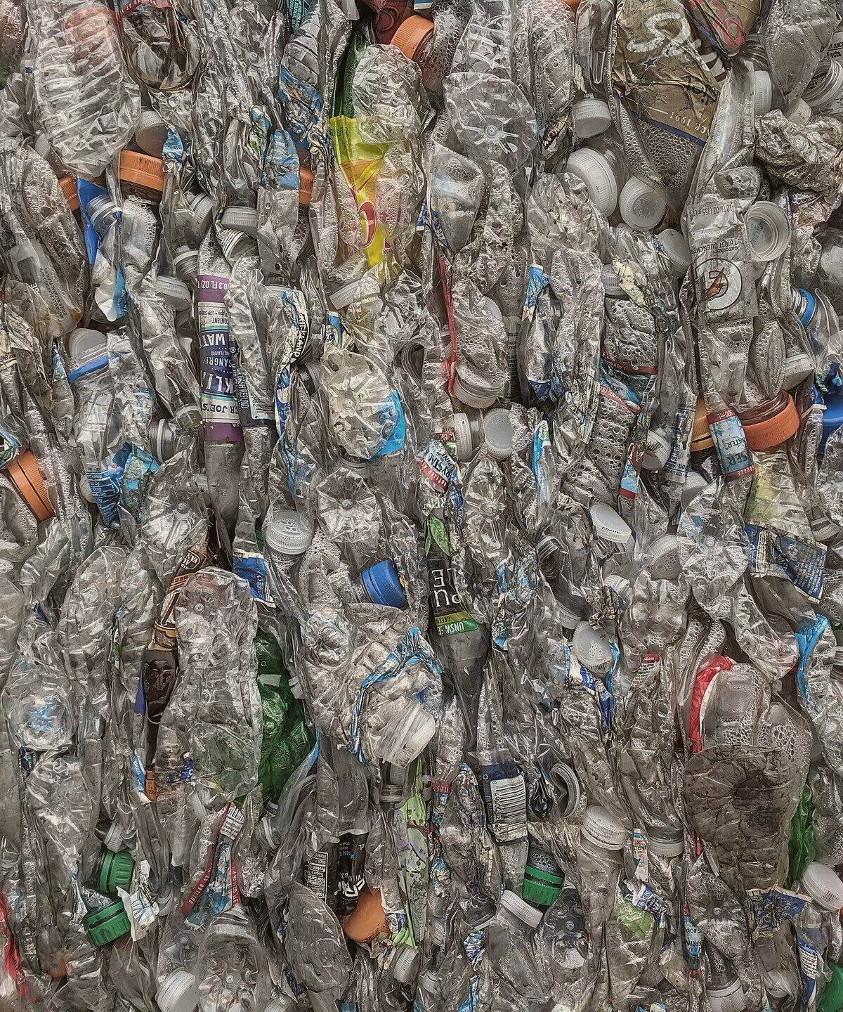 Compressed bales of collected packaging stacked for recycling